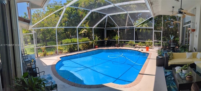 view of swimming pool with a patio area, ceiling fan, and a lanai