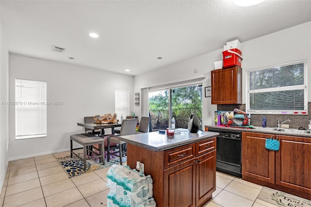 kitchen with tasteful backsplash, a center island, sink, light tile patterned floors, and black dishwasher