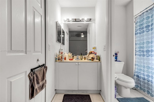 bathroom featuring tile patterned flooring, vanity, toilet, and walk in shower