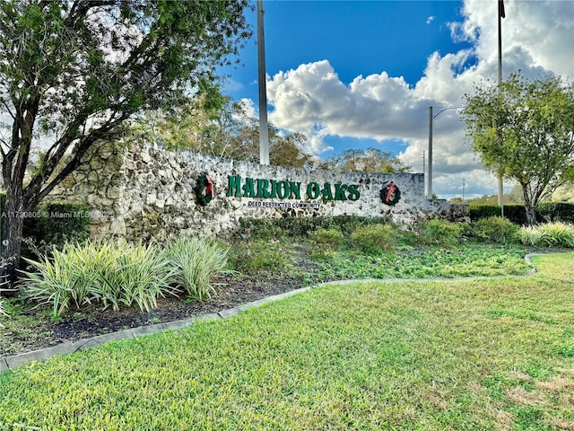 community / neighborhood sign featuring a lawn