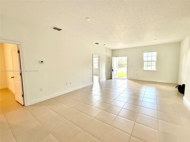 tiled spare room with a textured ceiling