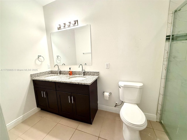 bathroom with tile patterned flooring, vanity, a shower with door, and toilet