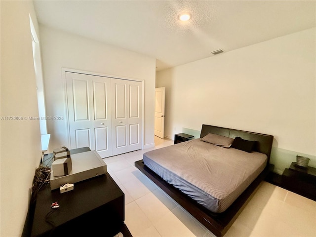 tiled bedroom featuring a closet and a textured ceiling