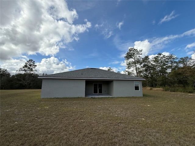 rear view of property featuring a yard and a patio area