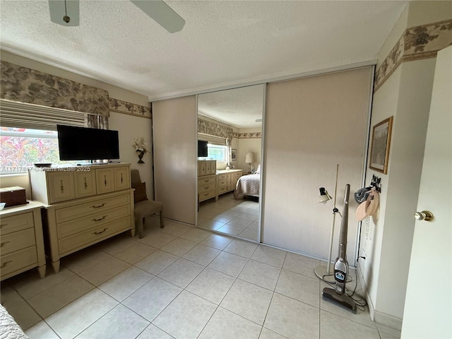 bedroom featuring multiple windows, ceiling fan, and light tile patterned flooring