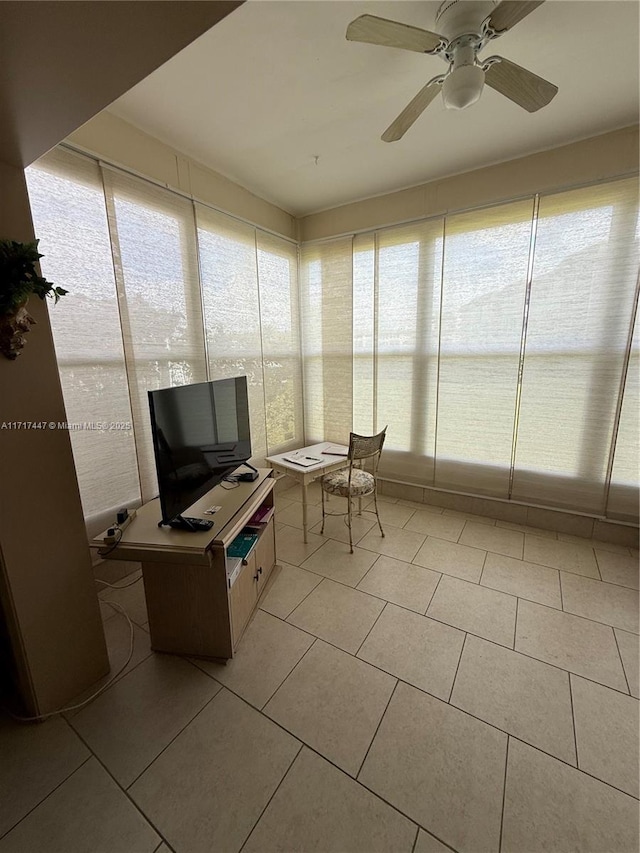 unfurnished sunroom with ceiling fan