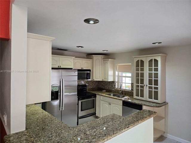 kitchen featuring decorative backsplash, dark stone counters, sink, and stainless steel appliances