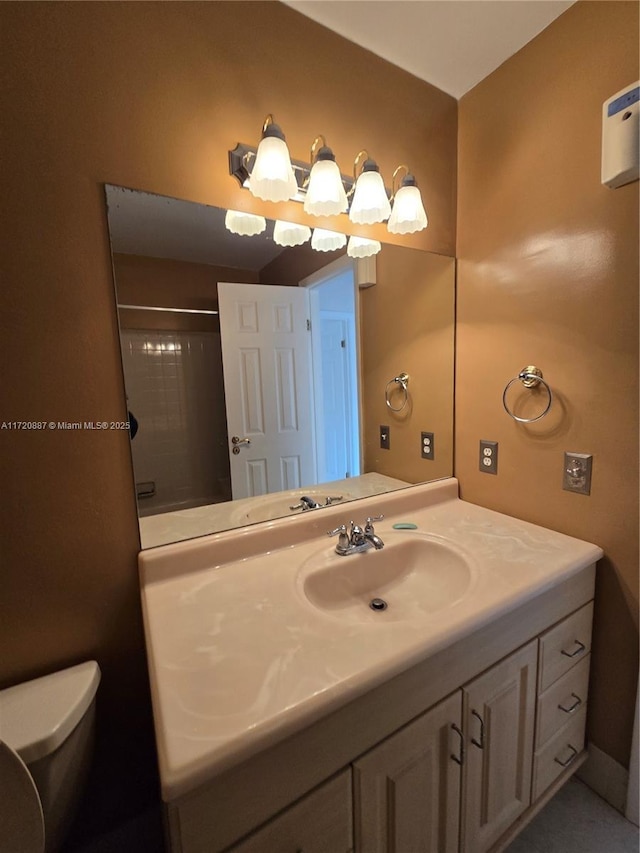 bathroom featuring toilet, a shower, and vanity