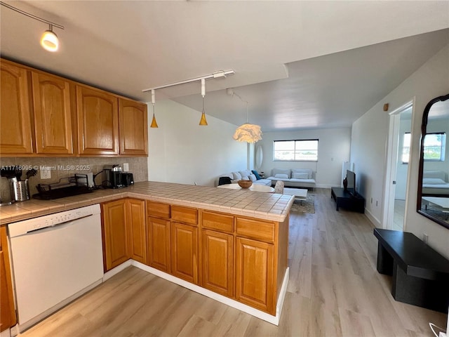 kitchen featuring tasteful backsplash, open floor plan, tile countertops, a peninsula, and dishwasher