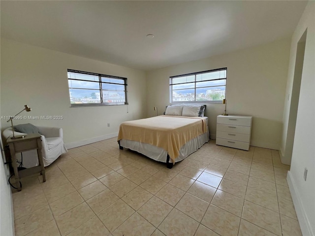 bedroom featuring light tile patterned floors and baseboards