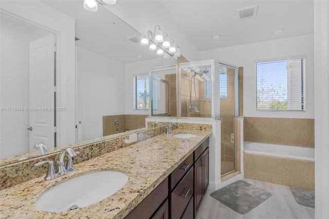 bathroom with hardwood / wood-style floors, vanity, separate shower and tub, and a healthy amount of sunlight