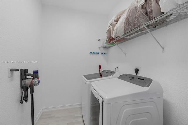 laundry room featuring independent washer and dryer and light wood-type flooring