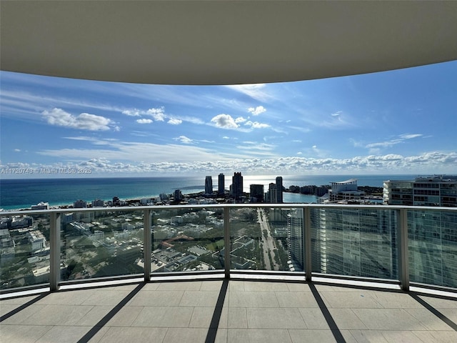 balcony featuring a water view and a city view