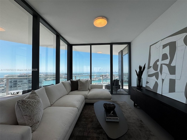 living area with a water view, expansive windows, and a city view