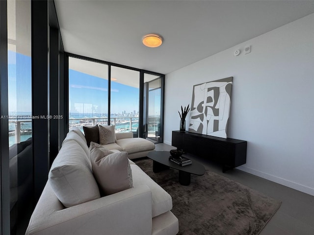 living area featuring a wall of windows, a city view, and baseboards