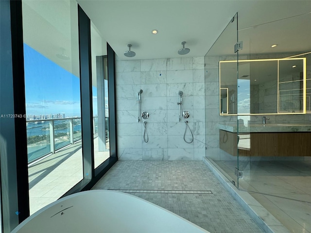 bathroom featuring a stall shower, a soaking tub, and vanity