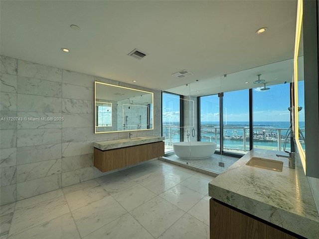 full bathroom with a wealth of natural light, two vanities, a shower stall, and visible vents