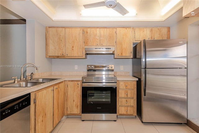 kitchen with a raised ceiling, light tile patterned flooring, sink, and stainless steel appliances