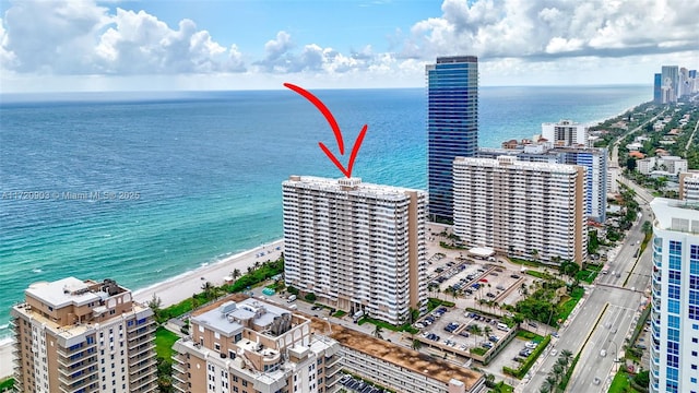 drone / aerial view with a water view and a beach view