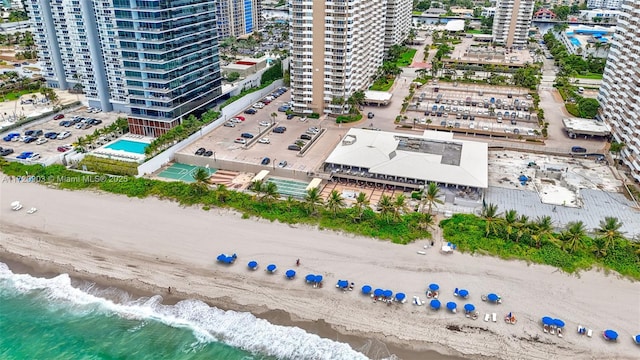 birds eye view of property with a water view and a beach view