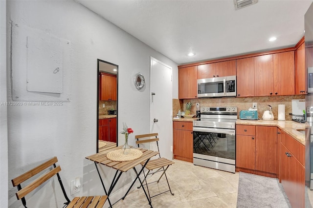 kitchen with decorative backsplash, light tile patterned floors, and appliances with stainless steel finishes