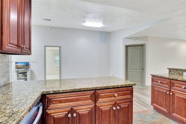 kitchen featuring kitchen peninsula and light stone countertops