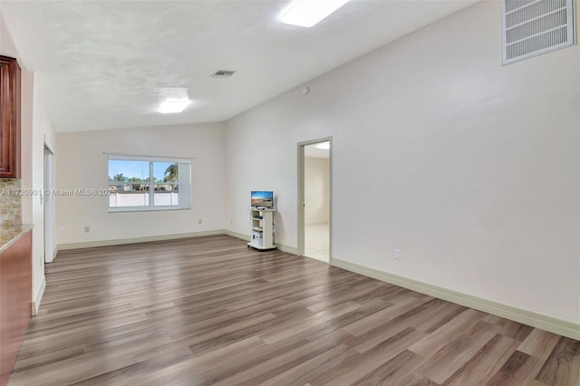 unfurnished living room featuring light hardwood / wood-style flooring and lofted ceiling