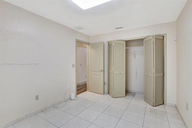 unfurnished bedroom featuring light tile patterned floors and a closet