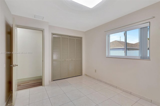 unfurnished bedroom with light tile patterned floors and a closet