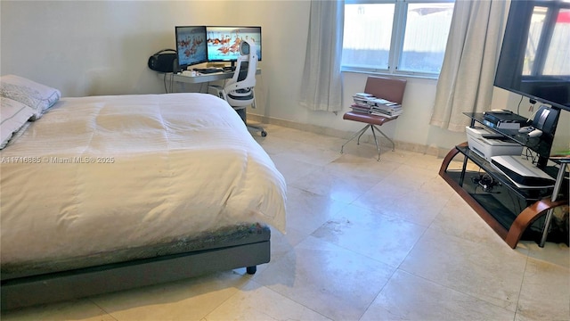 bedroom featuring light tile patterned floors and baseboards