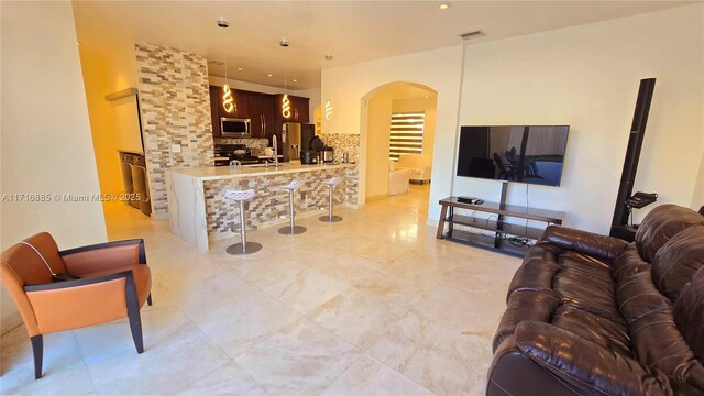 living room with arched walkways and visible vents