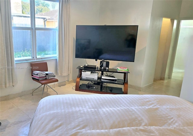 bedroom featuring multiple windows, baseboards, and light tile patterned floors