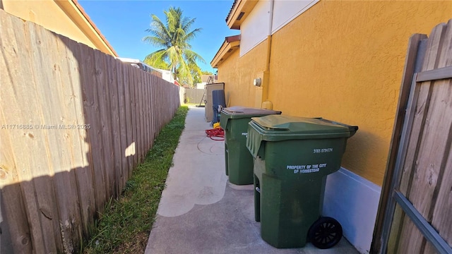 view of side of property featuring a patio area, a fenced backyard, and stucco siding