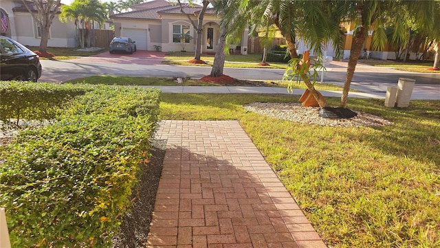 view of yard with decorative driveway and an attached garage