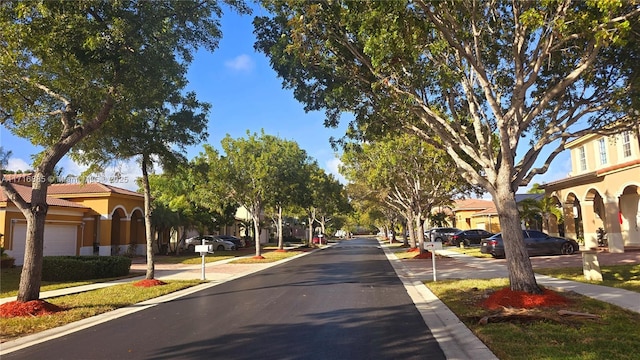 view of road with sidewalks, traffic signs, a residential view, and curbs