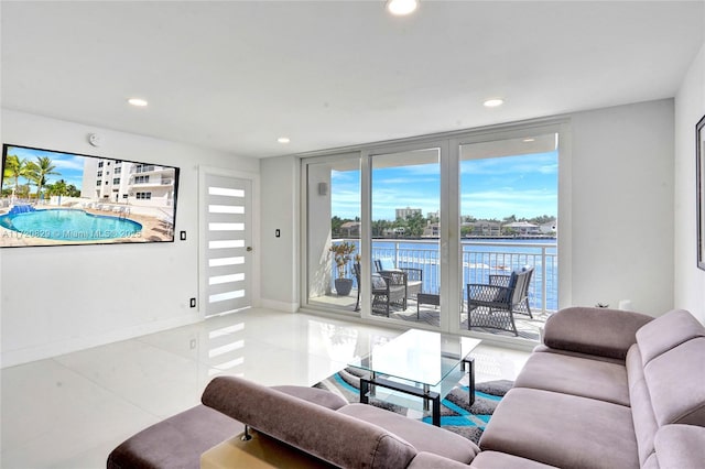 tiled living room with a water view and floor to ceiling windows