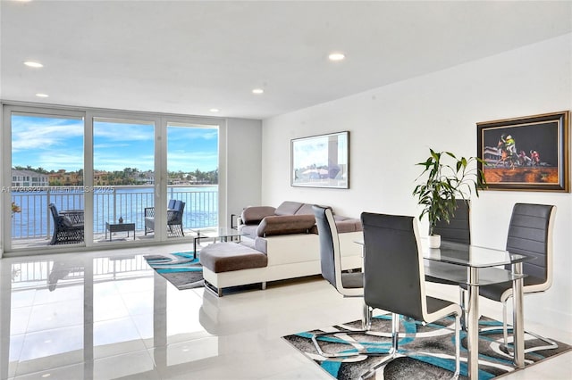 tiled dining room with a water view and a wall of windows