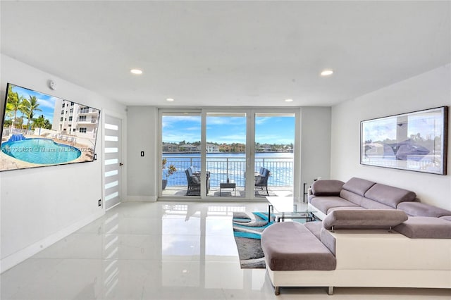 living room featuring light tile patterned floors, a water view, and expansive windows