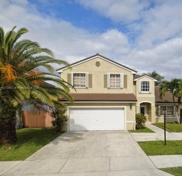 view of front of property featuring a front yard and a garage