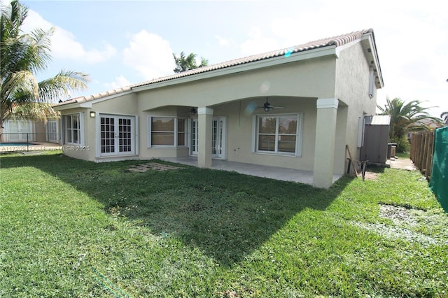 back of property with a lawn, a patio area, and ceiling fan