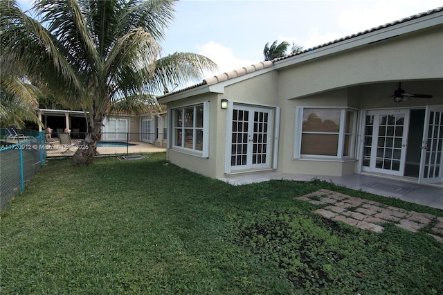 view of yard with ceiling fan and french doors