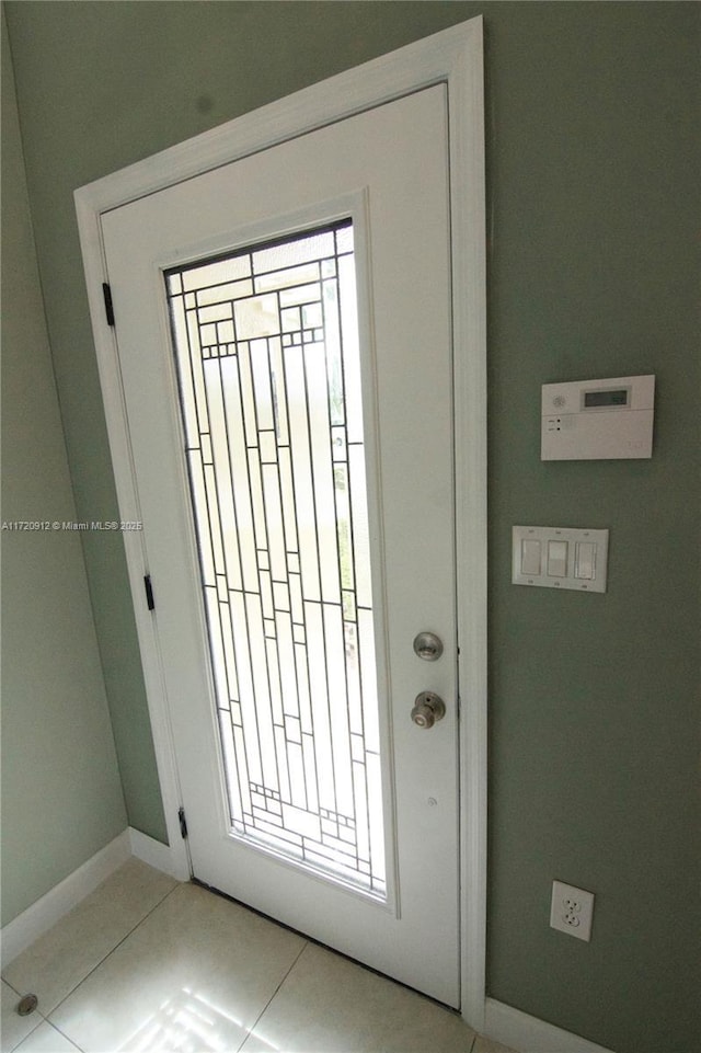 doorway to outside with light tile patterned floors