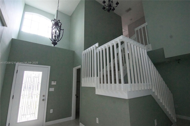 foyer entrance with a high ceiling, a wealth of natural light, and a notable chandelier