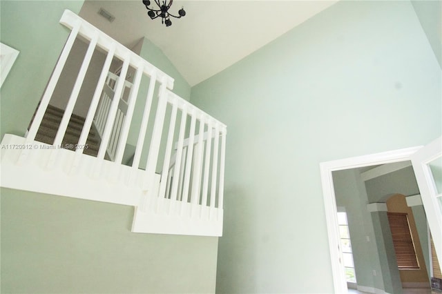 stairway with vaulted ceiling and a notable chandelier