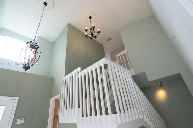 staircase featuring an inviting chandelier and a towering ceiling