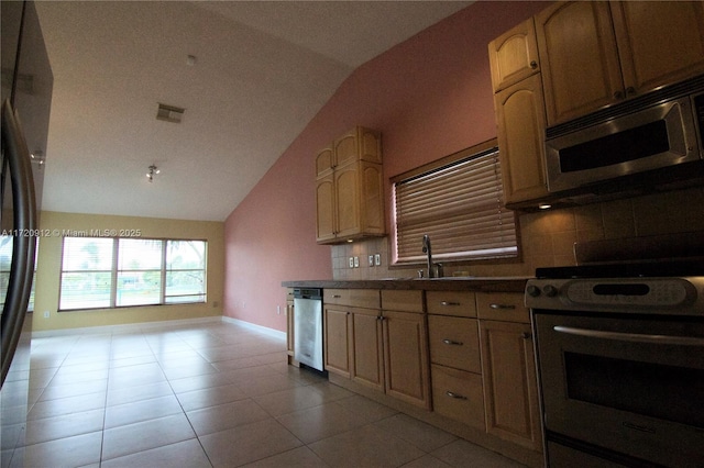 kitchen featuring stainless steel appliances, light tile patterned floors, decorative backsplash, lofted ceiling, and sink