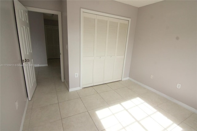 unfurnished bedroom featuring a closet and light tile patterned floors