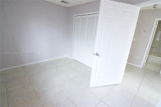 unfurnished bedroom with light tile patterned flooring and a closet