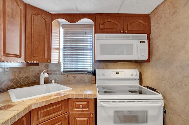 kitchen featuring decorative backsplash, sink, and white appliances