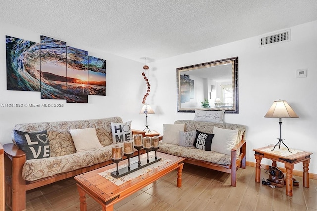 living room featuring a textured ceiling and hardwood / wood-style floors